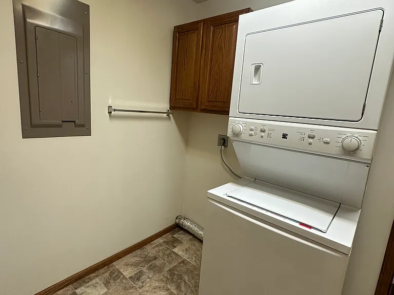 Stacked washer and dryer in separate laundry area.