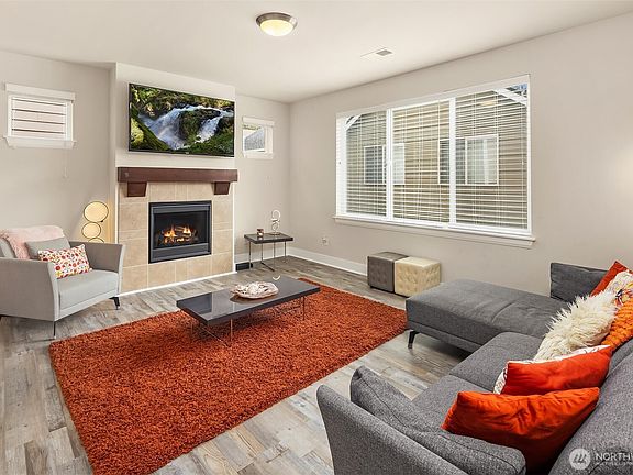 The inviting living space is situated just off the dining area and kitchen, offering a comfortable and welcoming spot to unwind.>