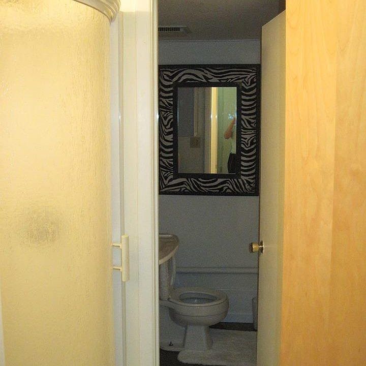 Half moon shower is attached to separate sink & toilet area. The two doors in this photo show how private the "water closet" can be.