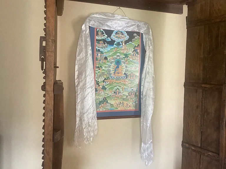 painting of Medicine Buddha behind the chinese doors in the living room.