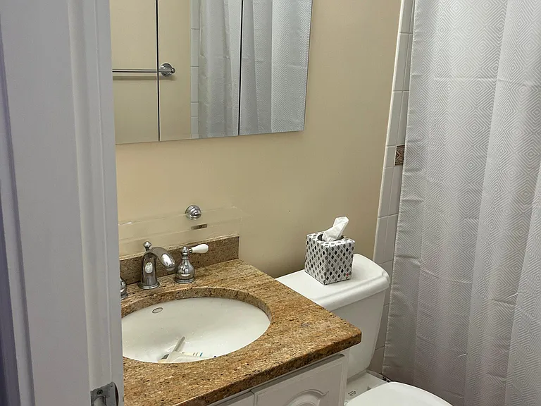 Full bath with walk-in shower located in the hall between the bedrooms.