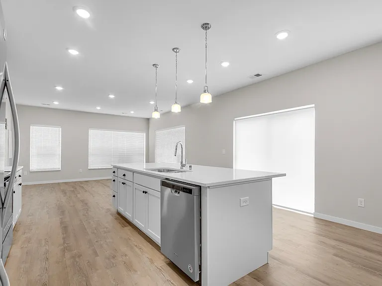 Modern kitchen with sleek white cabinetry, spacious island, and bright lighting, perfect for gourmet cooking. Modern kitchen with sleek white cabinetry, spacious island, and bright lighting, perfect for gourmet cooking.