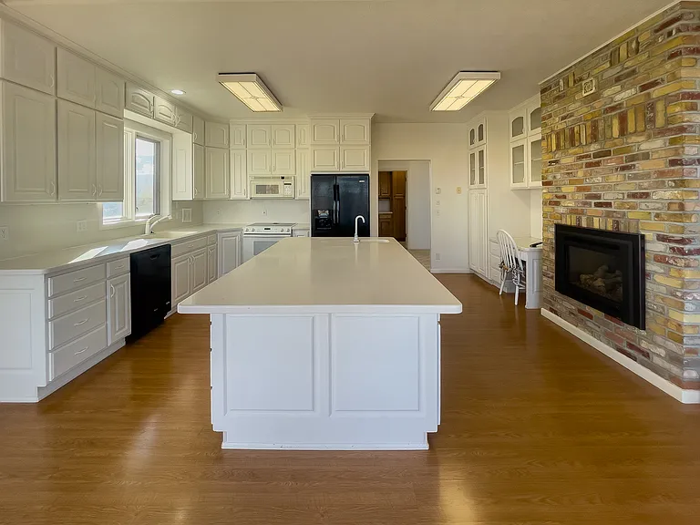 The aged brick accents, with built in propane fireplace brings warmth and homeyness into the large kitchen.