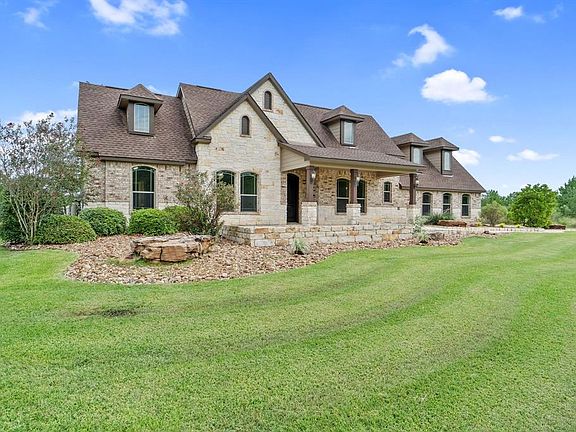 Beautiful stone and brick exterior with seating area in front.
