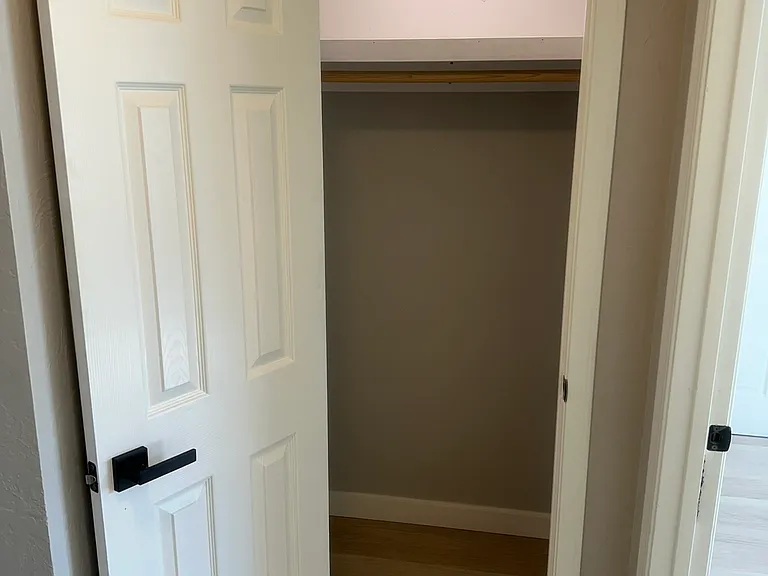 Hallway closet with fresh paint and solid new flooring