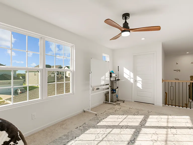 Bright bonus room with large windows showcasing stunning sunrise and mountain views, perfect for an office, guest room, or cozy retreat!