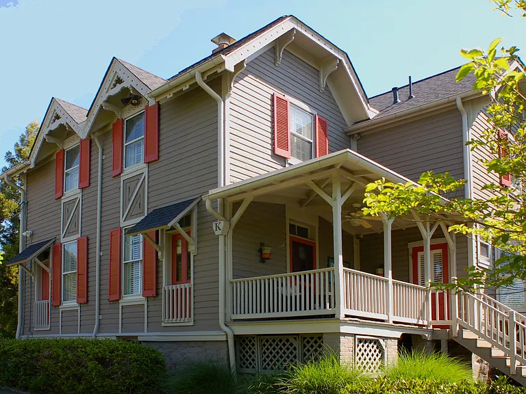 rear porch that leads to a private backyard oasis with two patios, a garden, and fenced yard