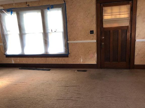 Living Room looking at the front door. Currently there is plastic over the windows that can be removed.