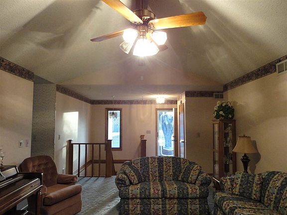 Living room view from fireplace towards front door and stair case to basement.