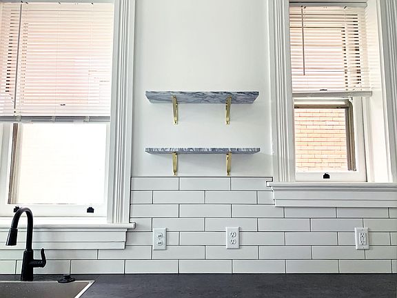 Beautiful galley kitchen with marble floating wall shelves.