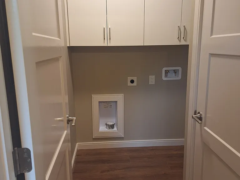 Laundry room with washer and dryer hook-ups and storage.