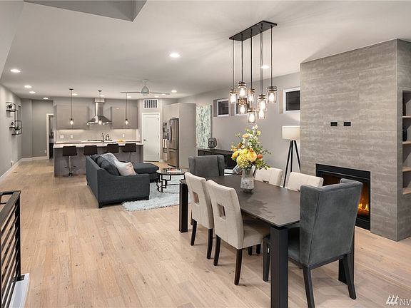 Great room style main floor seamlessly connects kitchen to living and dining area. Light filled space further accented by designer selected fixtures and finishes