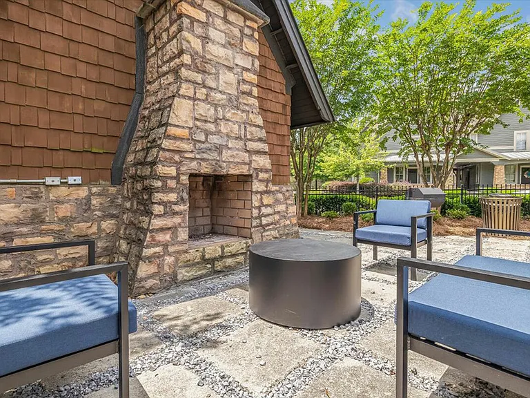 Unwind by the outdoor fireplace at The Cottages of Hattiesburg.
