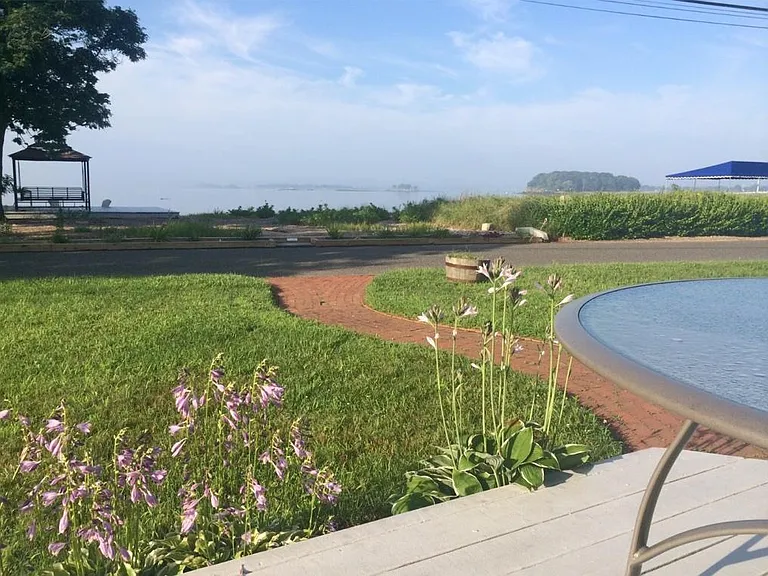 Your private beach and beach deck is just across from an outside deck off the house and a spacious green lawn