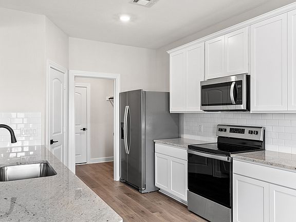 The kitchen has white cabinetry.