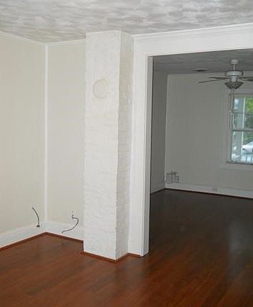 View from dining area looking back toward front living room. Chimney for wood burning stove remains but is capped and painted.