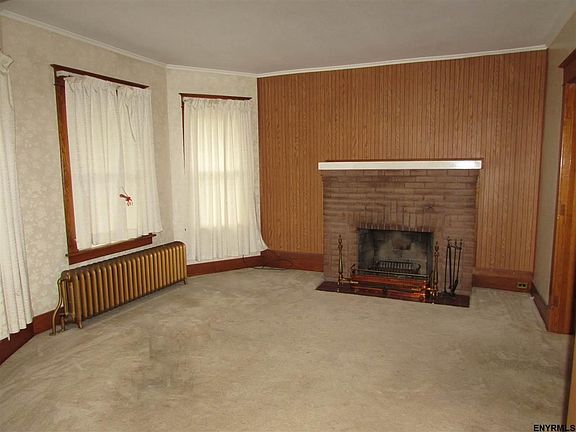 Wood burning fireplace. Carpet over wood floors.