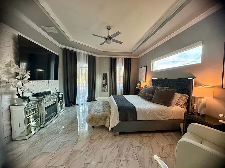 Master Bedroom-electronic shades, adjustable purple 3 bed, fireplace, and scenic waterfront view