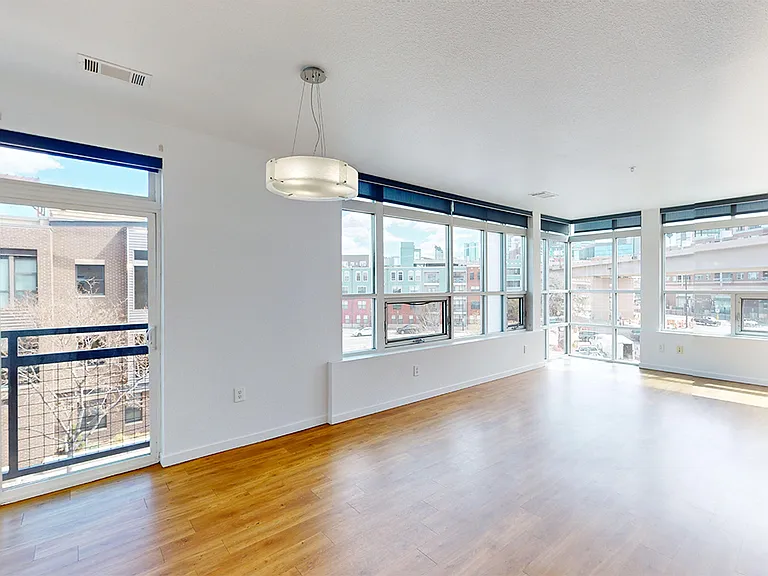 Apartment dining and living room with wood-style flooring.