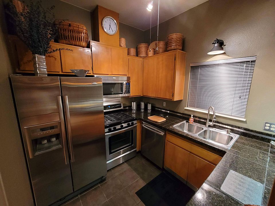 Kitchen with high ceiling. All Stainless Steel appliances, granite counters, designer lighting and a three-speed ceiling fan
