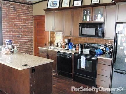 Kitchen : Door leading into extra bedroom. Shelves and drawers inside island