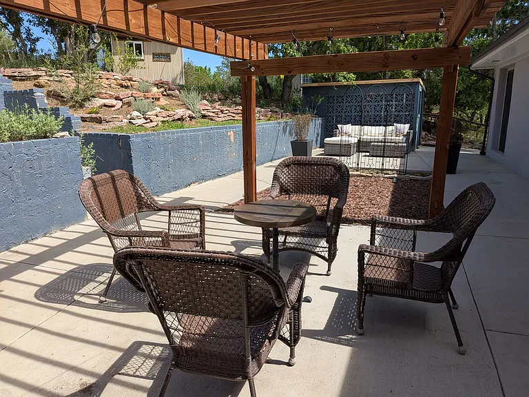 Large patio with trellis and several seating areas is accessible from the Dining Room, the Kitchen and the Master Bedroom