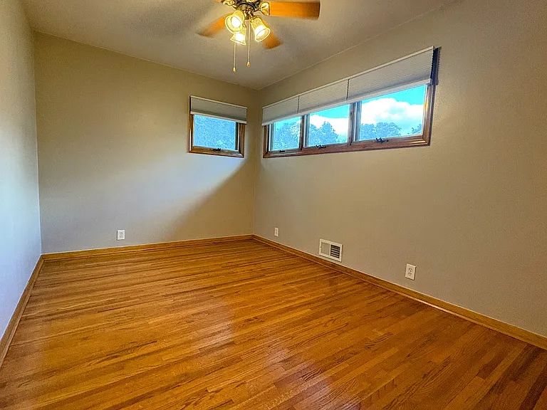 2nd Bedroom. Hardwood floors. Ceiling fan. Raised awning-style windows provide privacy and invite in the sunshine.