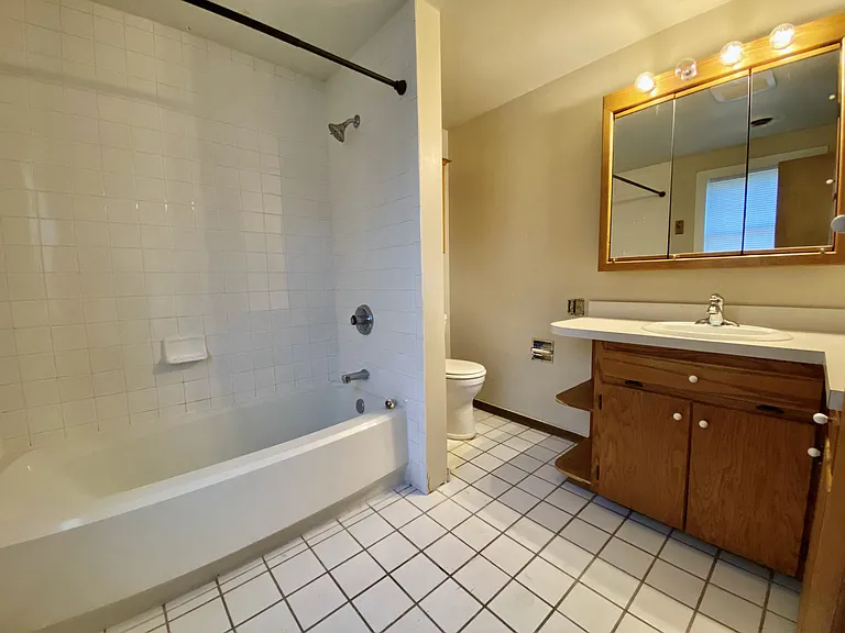 Inviting bathroom with a clean white bathtub, warm wood cabinetry, and soft ambient lighting. Inviting bathroom with a clean white bathtub, warm wood cabinetry, and soft ambient lighting.