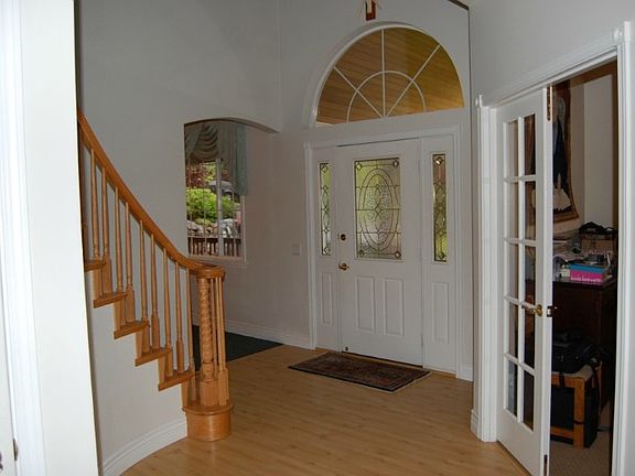 Spacious, open entry - curved staircase up - durable laminate wood entry