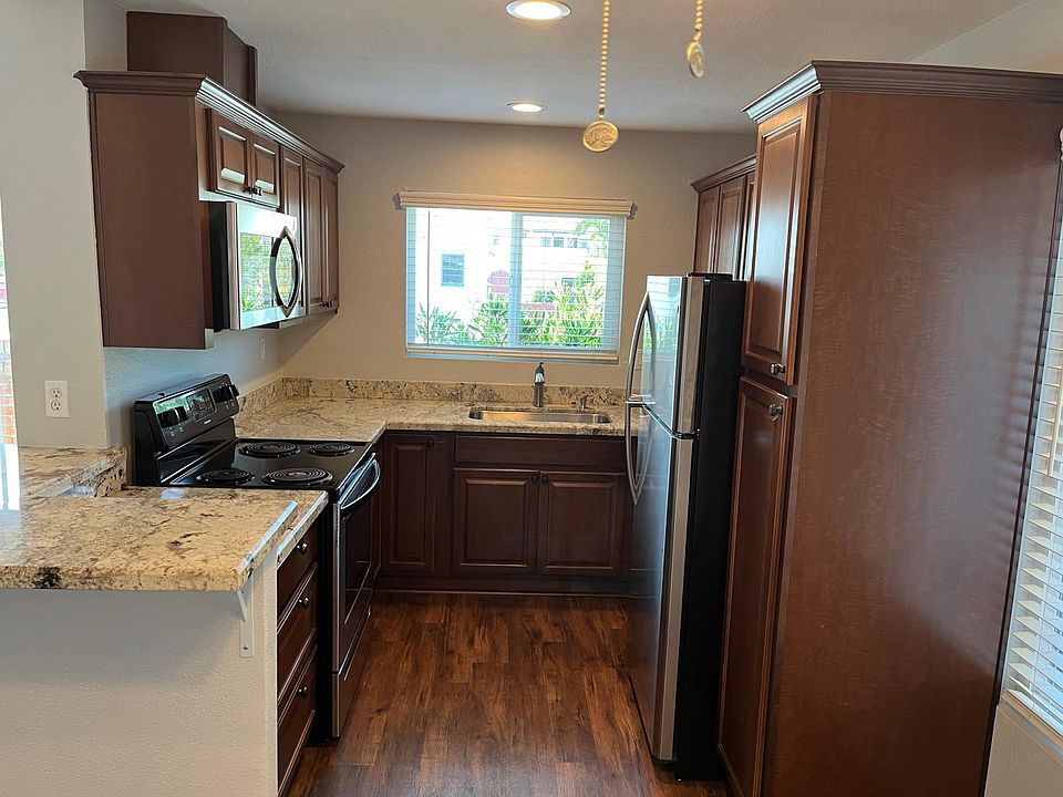 Kitchen with recessed cans, microwave, electric range/oven and frig.
