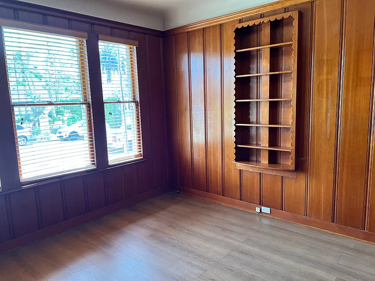 Third bedroom - featuring original wood paneling, built-ins, new LVT flooring, ample closet.