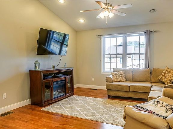 The living room, like the entire living area, features recessed lighting, a vaulted ceiling, and hardwood floors