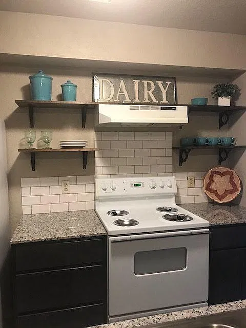 New kitchen with granite and open shelving and subway tile b
