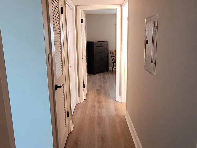 Main hallway between the bedrooms with new flooring and lighting.
