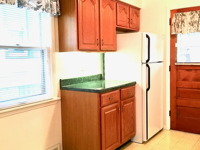 Efficient kitchen with appliances. Clean refrigerator.