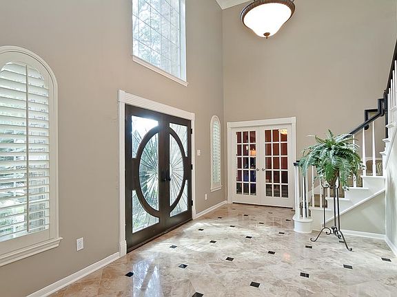 Dramatic and stately, the entryway invites you into the home. Winding staircase, marble & tile accent floor and soaring ceilings.
