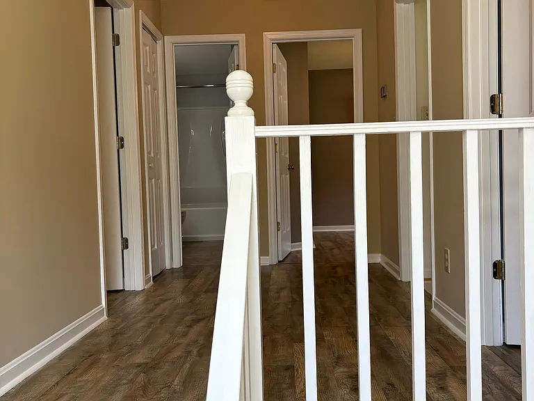 View of 2nd level hall from landing in front of large arched window.