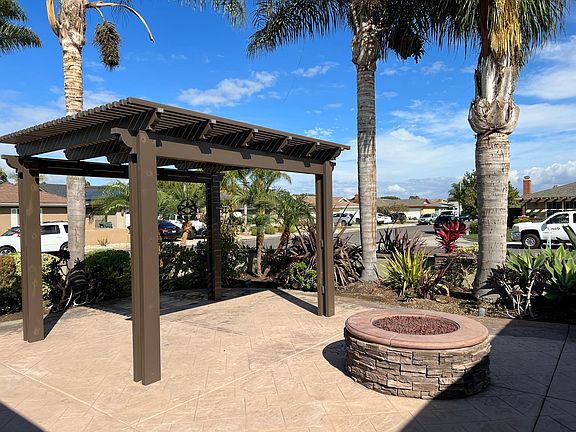 Enclosed front patio with pergola and fire pit, perfect for entertaining friends and neighbors or enjoying a quiet evening under the stars!