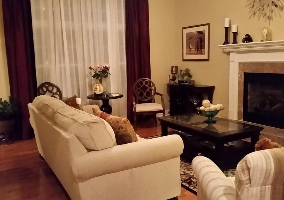 Living Room has 10 feet high ceiling, a gas fireplace, and a large window facing the backyard. Hardwood floors throughout the entire first floor
