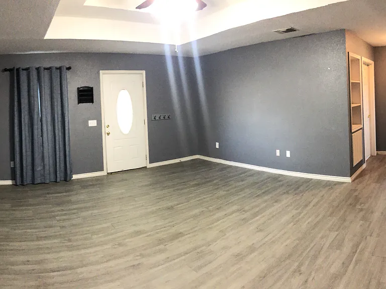 Pano of large livingroom with entry door, window & hallway to second bath & both bedrooms. Photo taken from kitchen