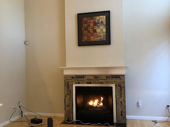 Living room with vaulted ceilings, cozy fireplace, and custom tiling