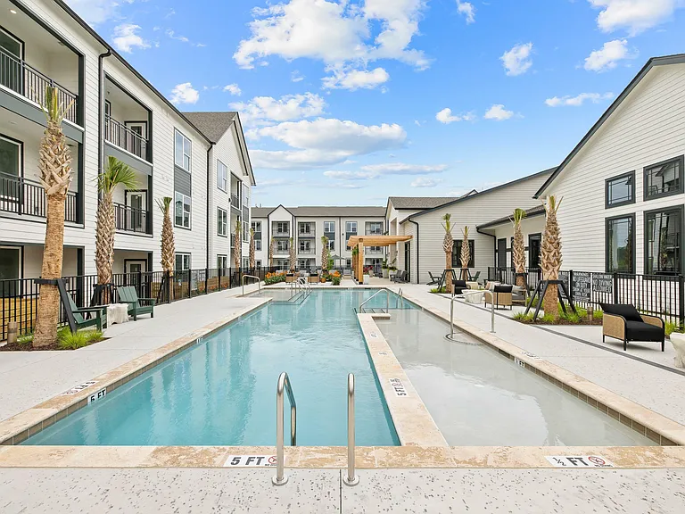 Luxury apartment pool with expansive sun deck, tanning ledge, and resort-style outdoor amenities.