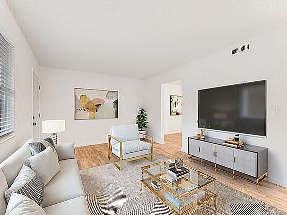 Bright and modern living room with sleek furniture, a large TV, and stylish decor in an inviting apartment.