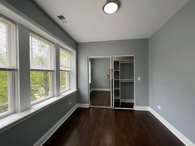 2nd bedroom with built-in organizer closet and mirrored doors.