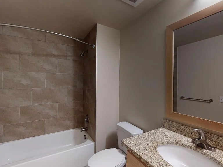 Apartment bathroom with tile flooring.