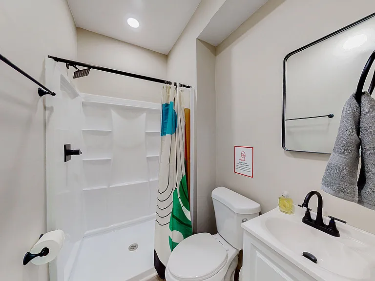 Full bathroom with walk-in shower, built-in shelving, and a vanity with ample counter space and mirror.
