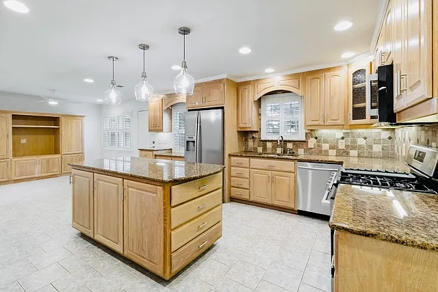 Spacious kitchen with large island, granite countertops, and stainless steel appliances.