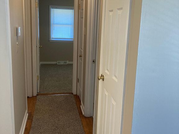 Hallway with coat and linen closets.