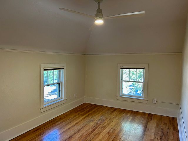 living room with angled ceiling, windows face south and west
