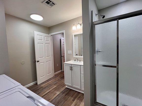 Second full bath with laundry complete with new Amana appliances, luxury vinyl plank flooring vanity and shower.